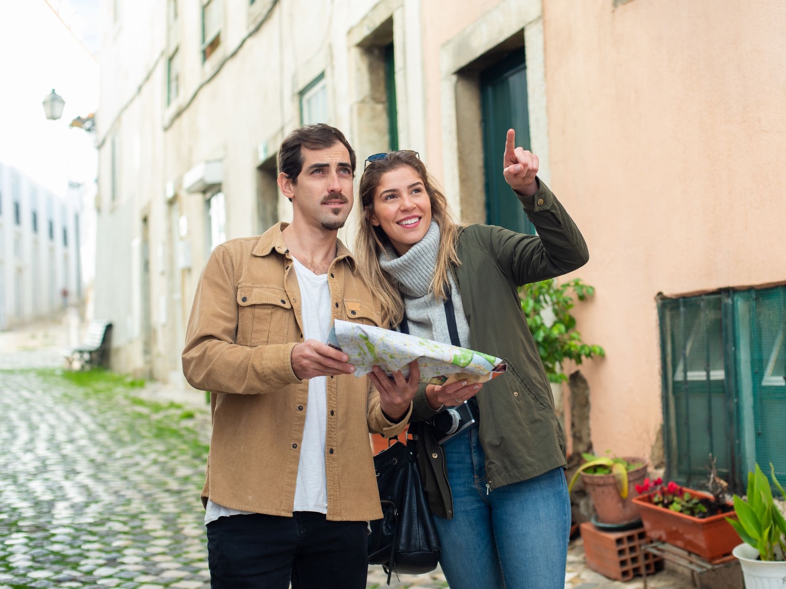 A couple looking over a paper map together on a residential street.