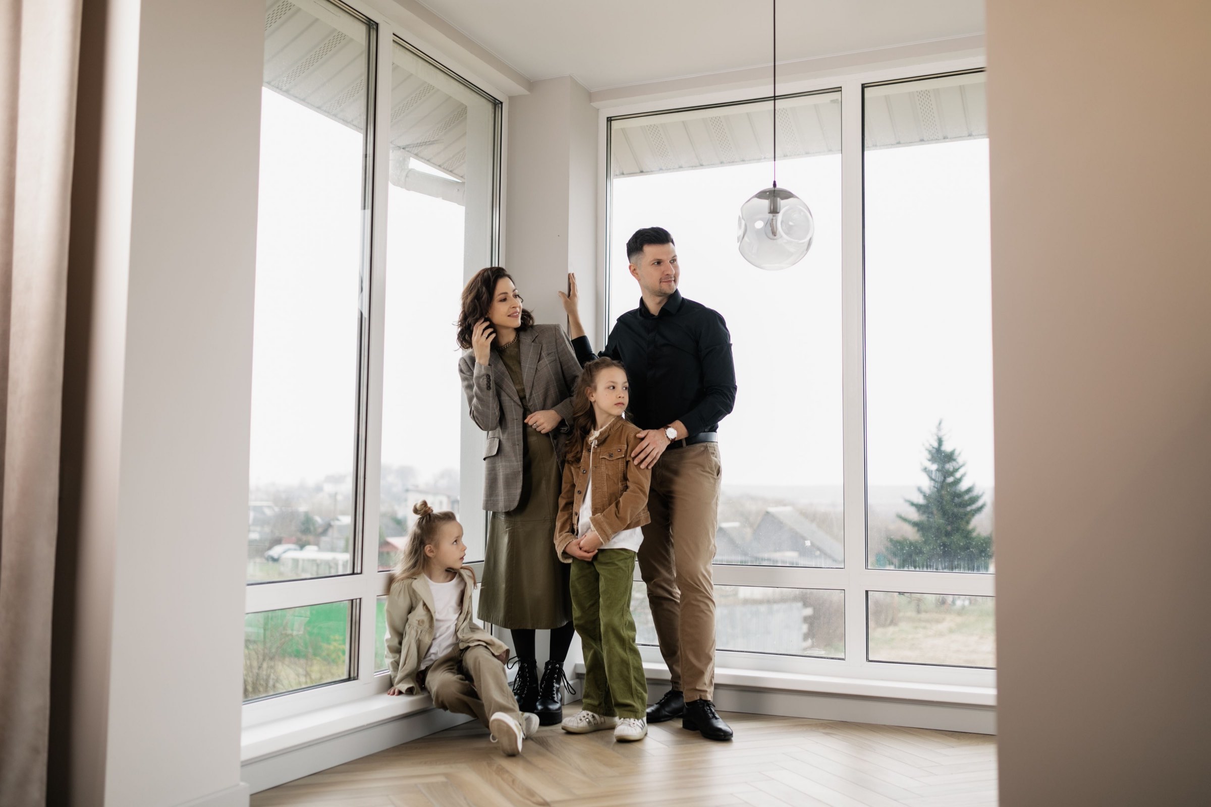 A family at the window of their empty house.