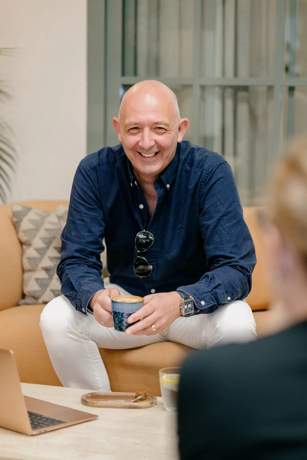 Kevin Martin, founder of Movi, smiling in conversation with a coffee cup in his hand.